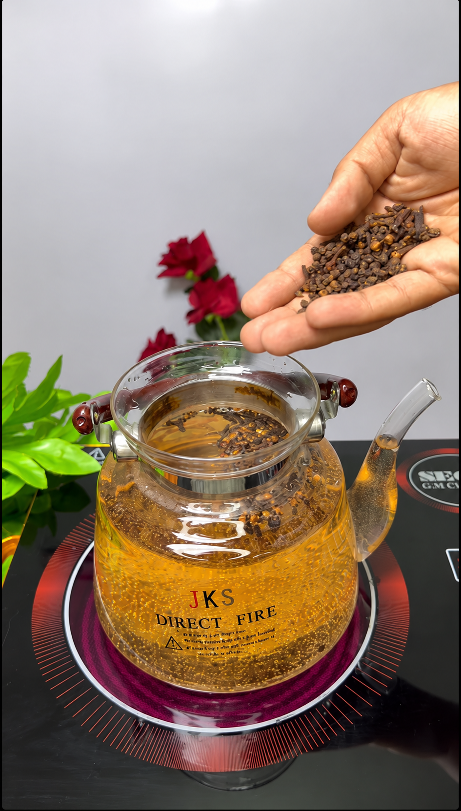 Tetera de vidrio con infusión de clavo de olor y pimienta negra